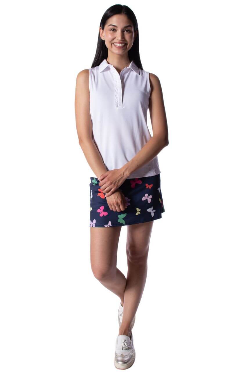 Cute women's golf outfit with white sleeveless polo and navy butterfly skort