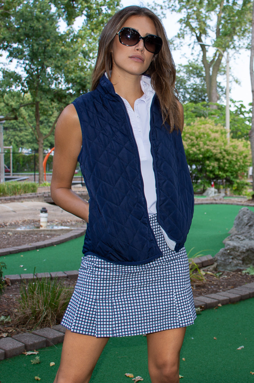 Women's navy golf outfit with gingham bestselling skort and a navy and white reversible wind vest