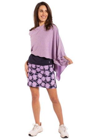 Woman wearing lavender poncho with matching cute floral golf skort