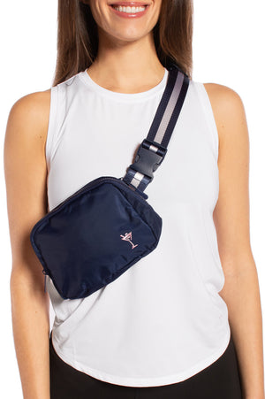 Stylish woman with over the shoulder everyday crossbody bag in navy with a light pink martini