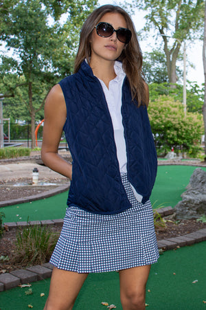 Women's navy golf outfit with gingham bestselling skort and a navy and white reversible wind vest