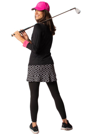 Women's black and white stretch skort paired with black leggings jacket and breast cancer hat